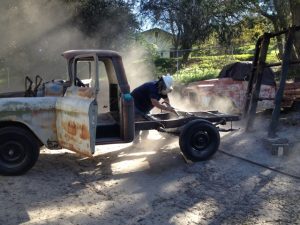 Jim Tronier getting to work sandblasting the 1956 Chevrolet truck frame.