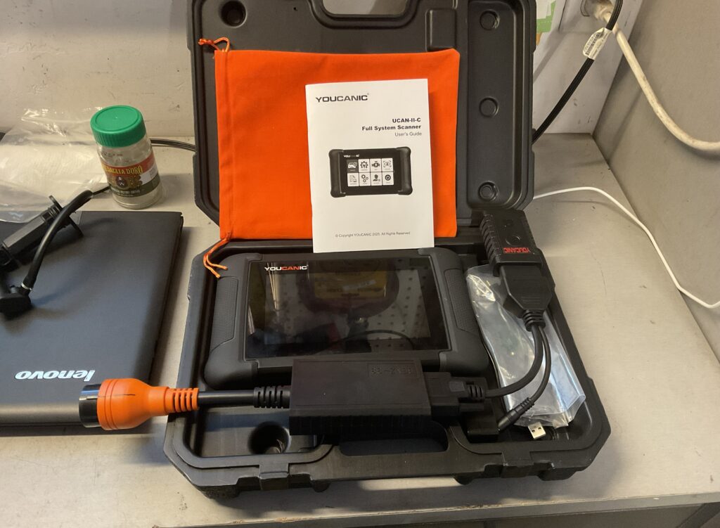 Youcanic UCAN-II-C full system scanner kit with user guide, displayed in a case alongside various cables and items.