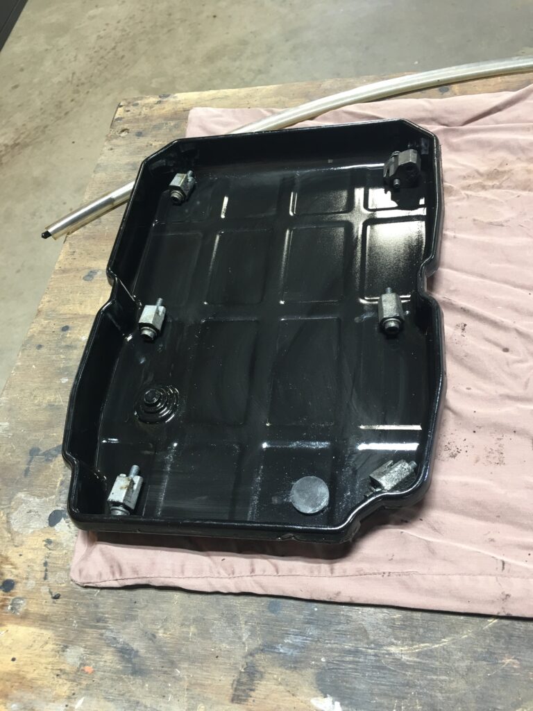 Top view of a black Mercedes transmission oil pan.