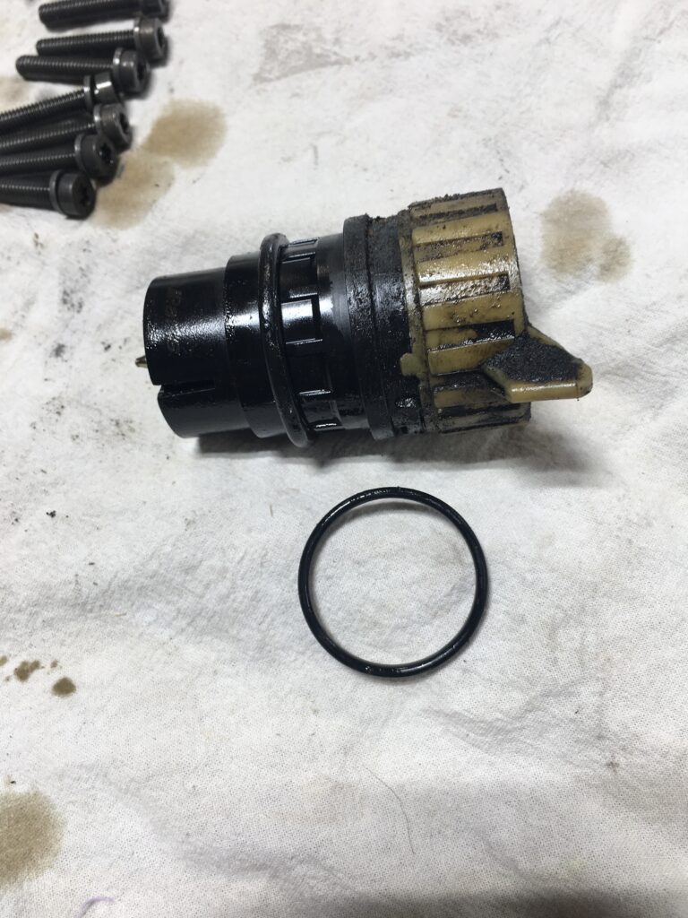 Close-up of a worn transmission connector with a dirty rubber O-ring.